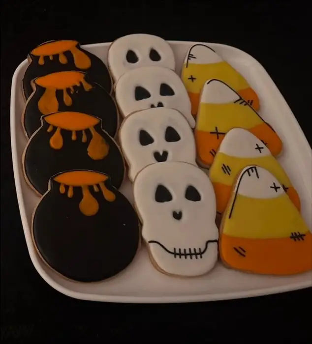 Halloween iced sugar cookies: ghosts, candy corn and black drip designs on a plate