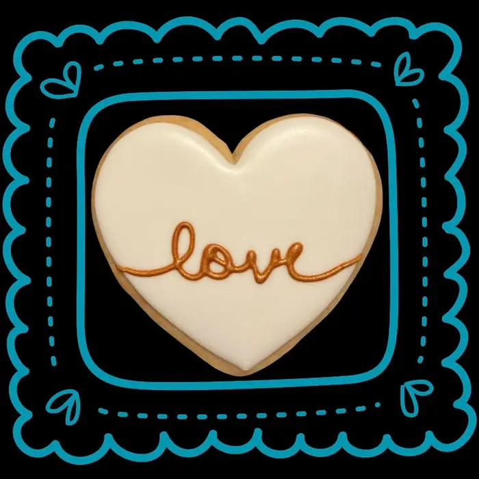 A single heart cookie iced with the word "love" in gold