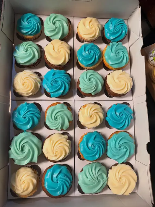 Trays of cupcakes swirled with blue and cream buttercream