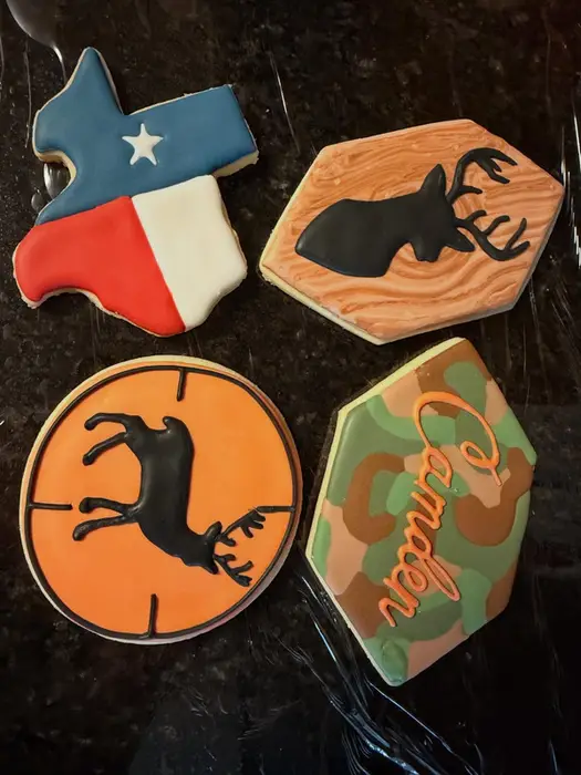 Hunting themed cookies with a Texas flag, a buck silhouette and camo lettering