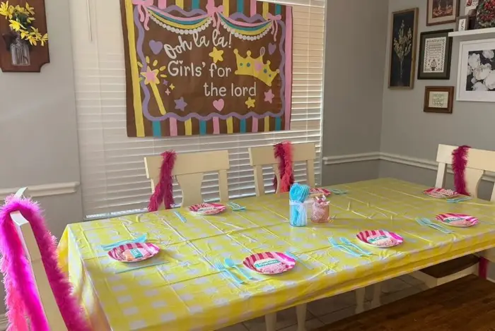 A party table set for the "Ooh la la! Girls' for the lord" event with a painted backdrop