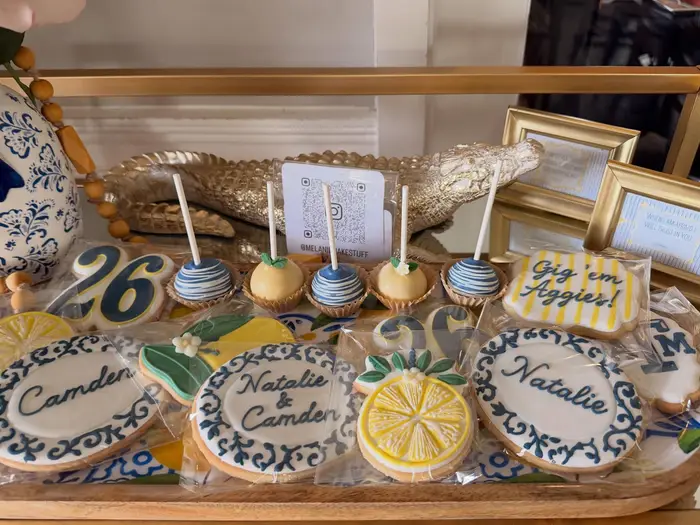 The Aggies graduation cookies and cake pops on a dessert table