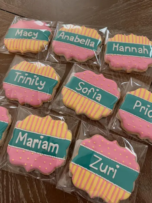 Personalised name cookies in pink, green and yellow for a group of graduates