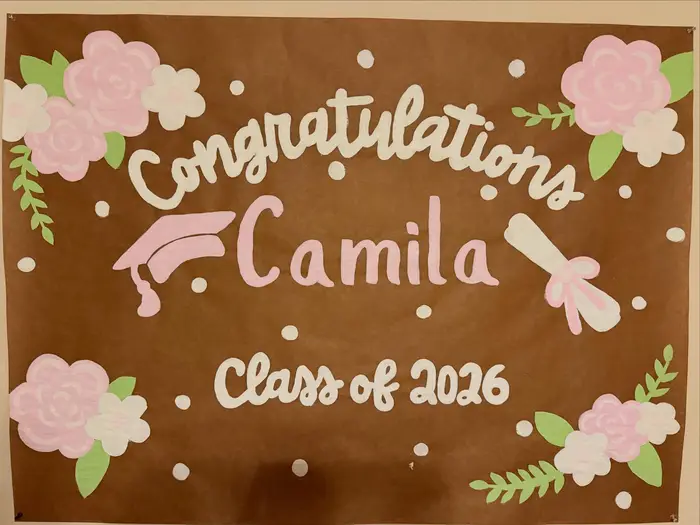 Hand-painted "Congratulations Camila, Class of 2026" poster with flowers