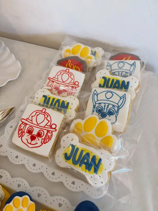 Paw Patrol cookies for Juan with character faces, a paw print and a bone