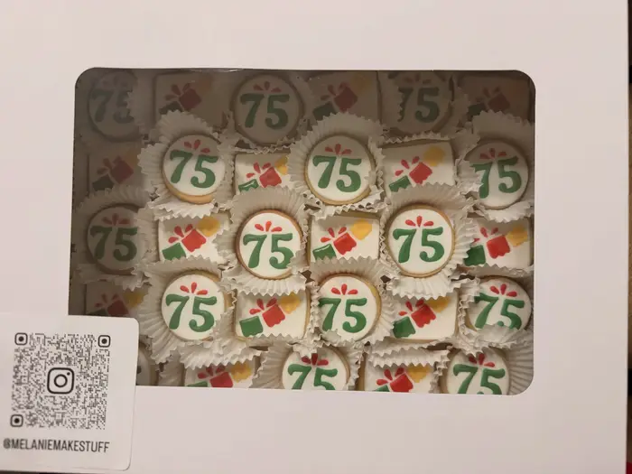 A boxed set of 75th birthday cookies in green and red